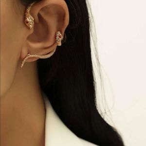 A set of snake earrings and two body jewellery